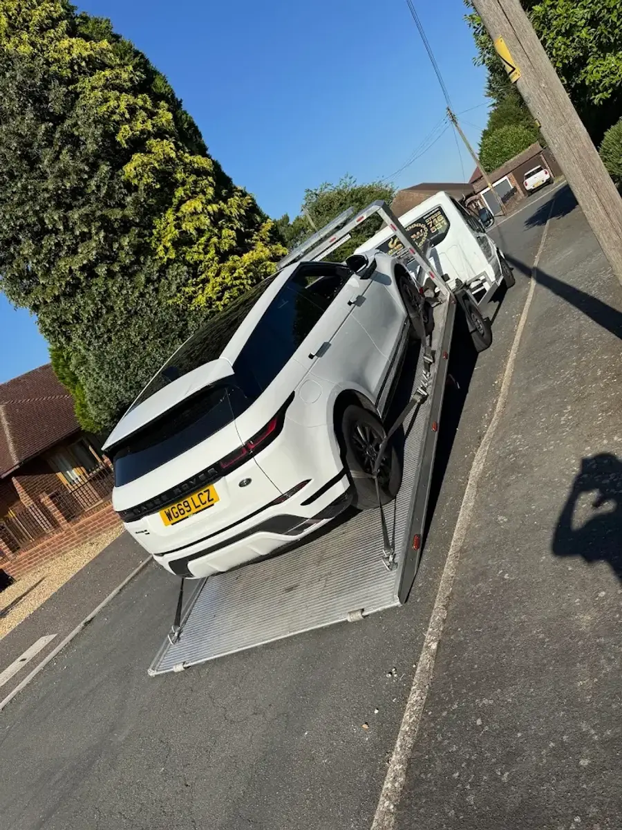 White Range Rover Evoque on a tilted flatbed bed