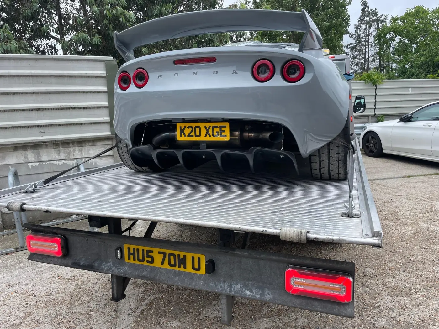 Grey Lotus sports car strapped on a HUS TOW flatbed