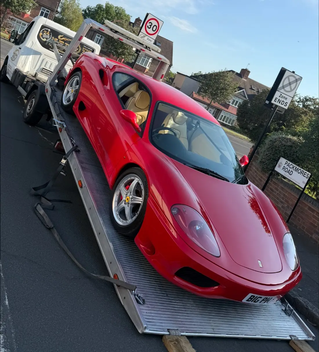 Red Ferrari 360 loaded on a HUS TOW tilting-bed recovery truck